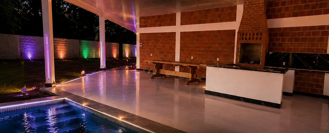 Quincho Aquarela de noche con piscina iluminada